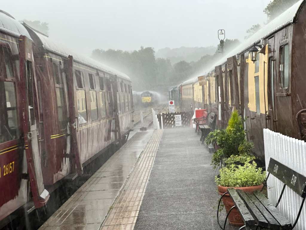 Very heavy rain on a train at a station platform.