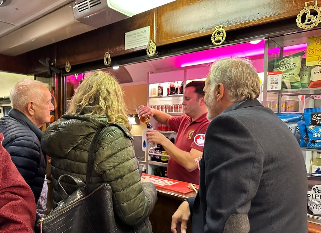 A person serving drinks at a busy bar.